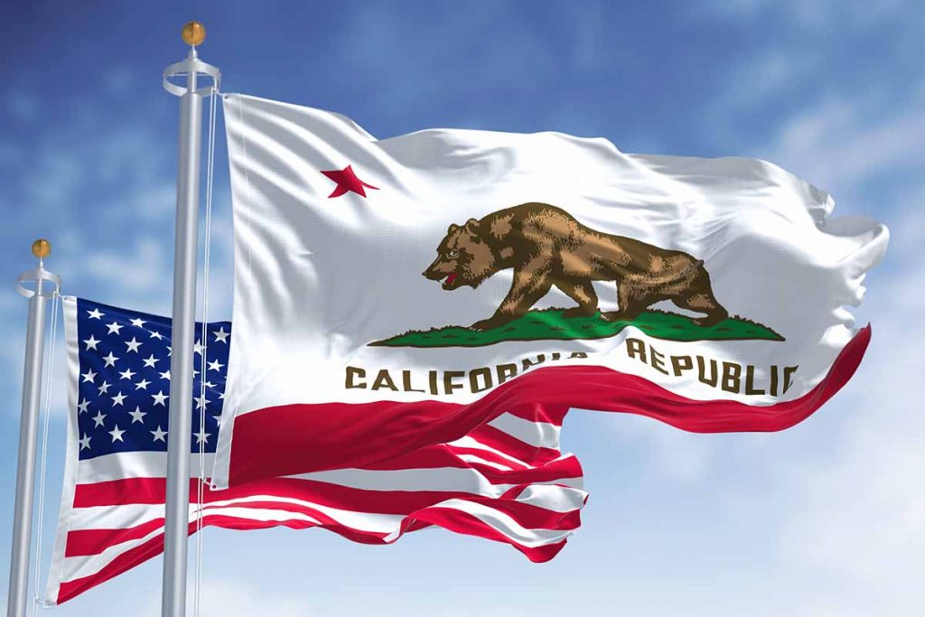 California flag and U.S. flag with blue sky background.