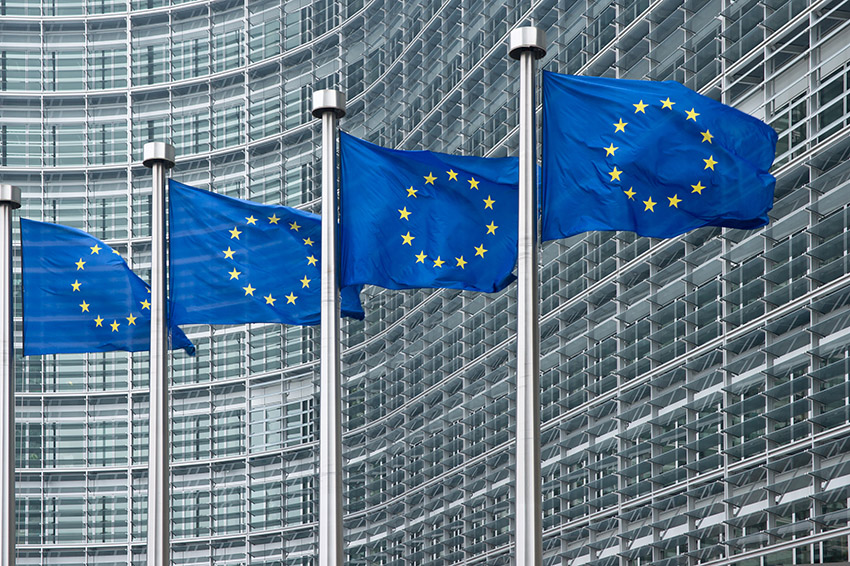 Row of E.U. flags outside the European Commission building.