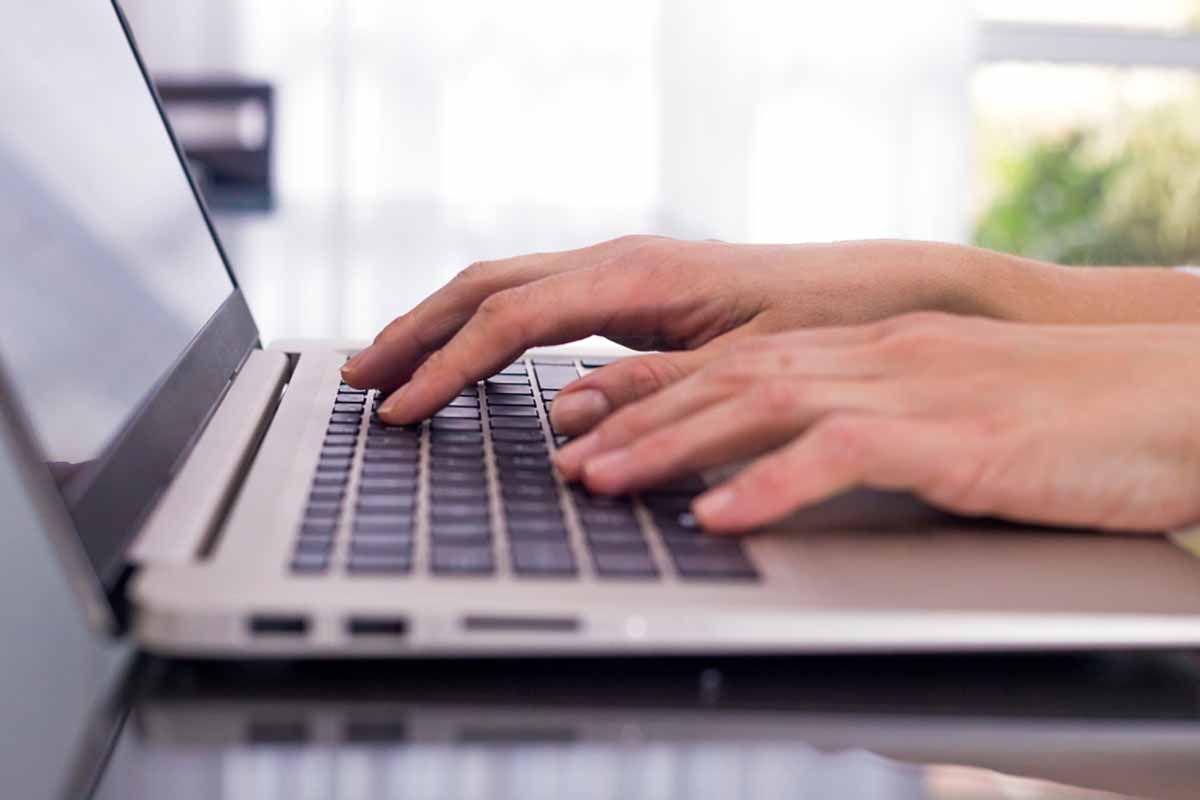 Hands at work on a laptop.