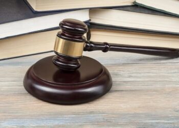 Court gavel on table with books.