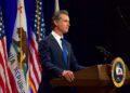 California Governor Gavin Newsom speaking at podium.