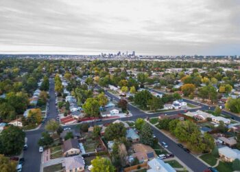 Aerial view of a Denver neighborhood with city skyline in background.