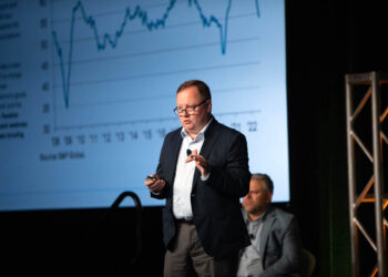 Joe Pickard speaks at the 2022 E-Scrap Conference with market graph on screen in the background.