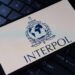 Interpol logo on phone, resting on a keyboard.