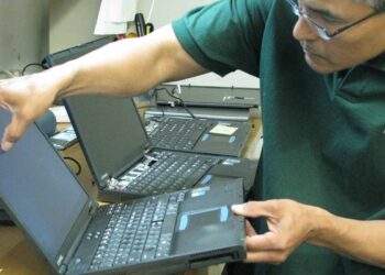 PlanITROI employee processing a device.