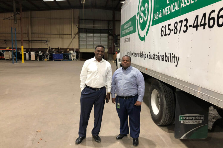S3 company CEO and Chairman stand by a company truck.