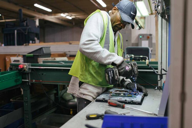 TechDump employee at work tearing down a device.