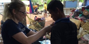 Researcher attaches monitoring device to e-scrap worker.