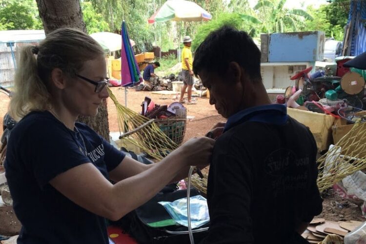 Researcher attaches monitoring device to e-scrap worker.