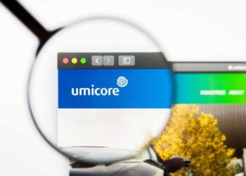 Umicore logo on a screen under a magnifying glass.