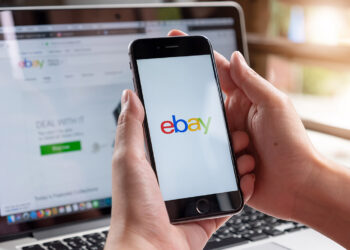 Smartphone and laptop with eBay on screen.