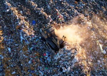 Landfill seen from above with equipment moving materials.