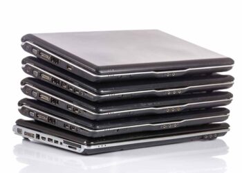 Laptops stacked awaiting repair.