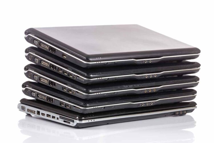 Laptops stacked awaiting repair.