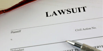 Documents to file a lawsuit with a pen.