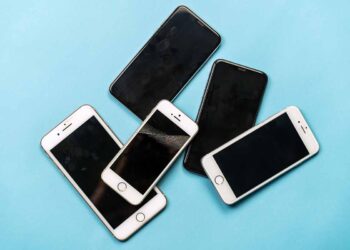 Used cell phones arranged on a blue background.