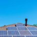 Solar panels on a residential roof with blue sky above.